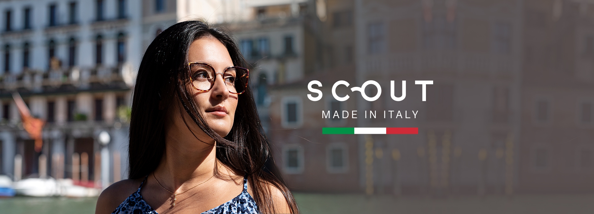 A woman wearing Colombina glasses frames next to the Scout: Made in Italy logo