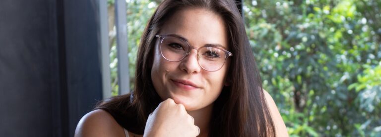 Brown-eyed lady wearing classes in front of a window