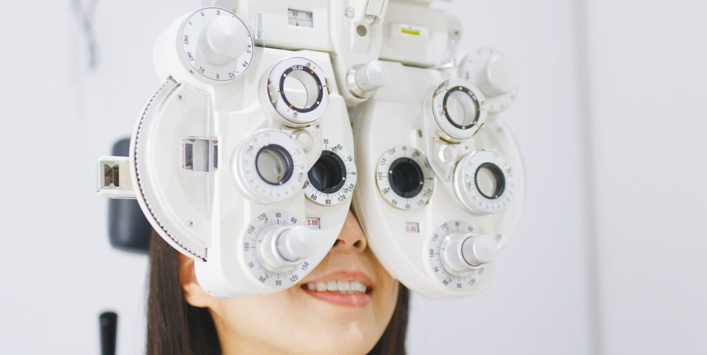 Woman having her eyes tested on eye test equipment