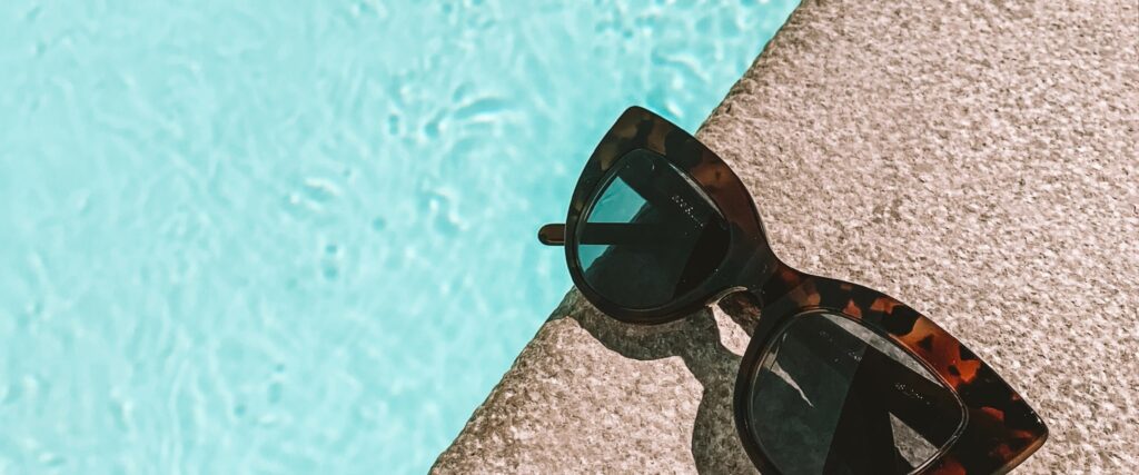 Sunglasses on the edge of a swimming pool