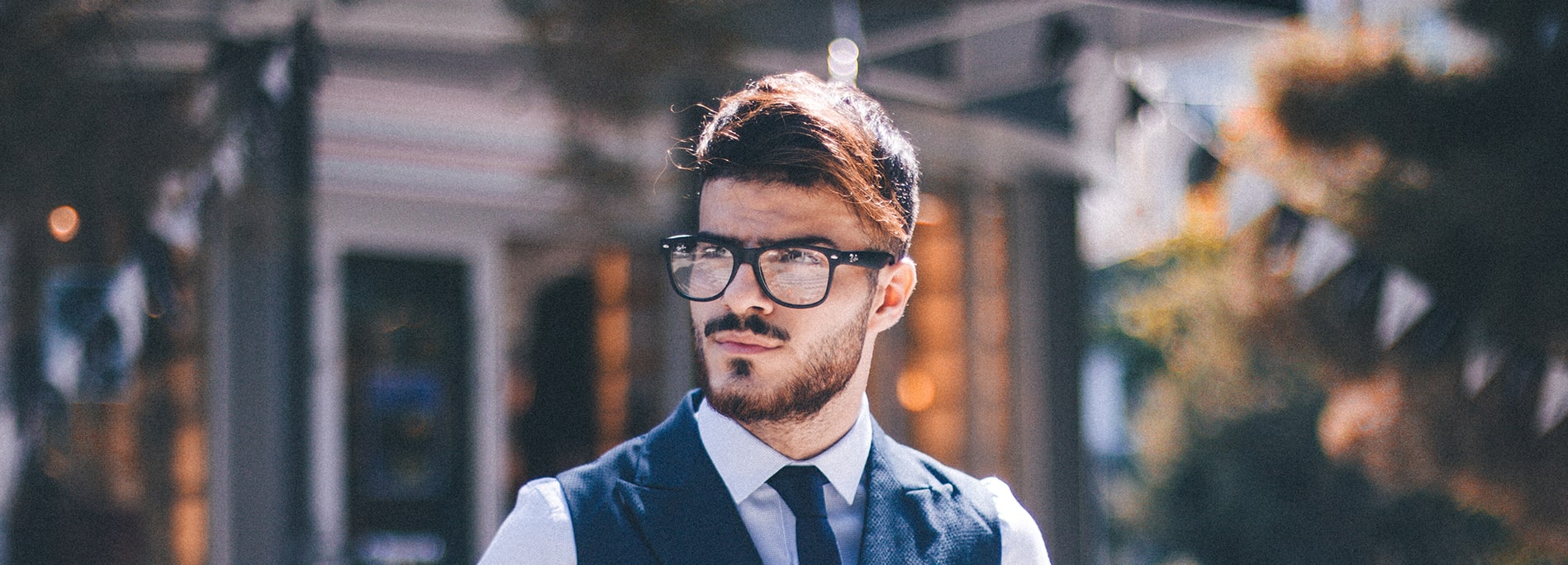 Man with beard wearing black round frames outdoors