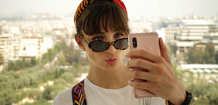 Woman wearing sunglasses pouting while taking a selfie
