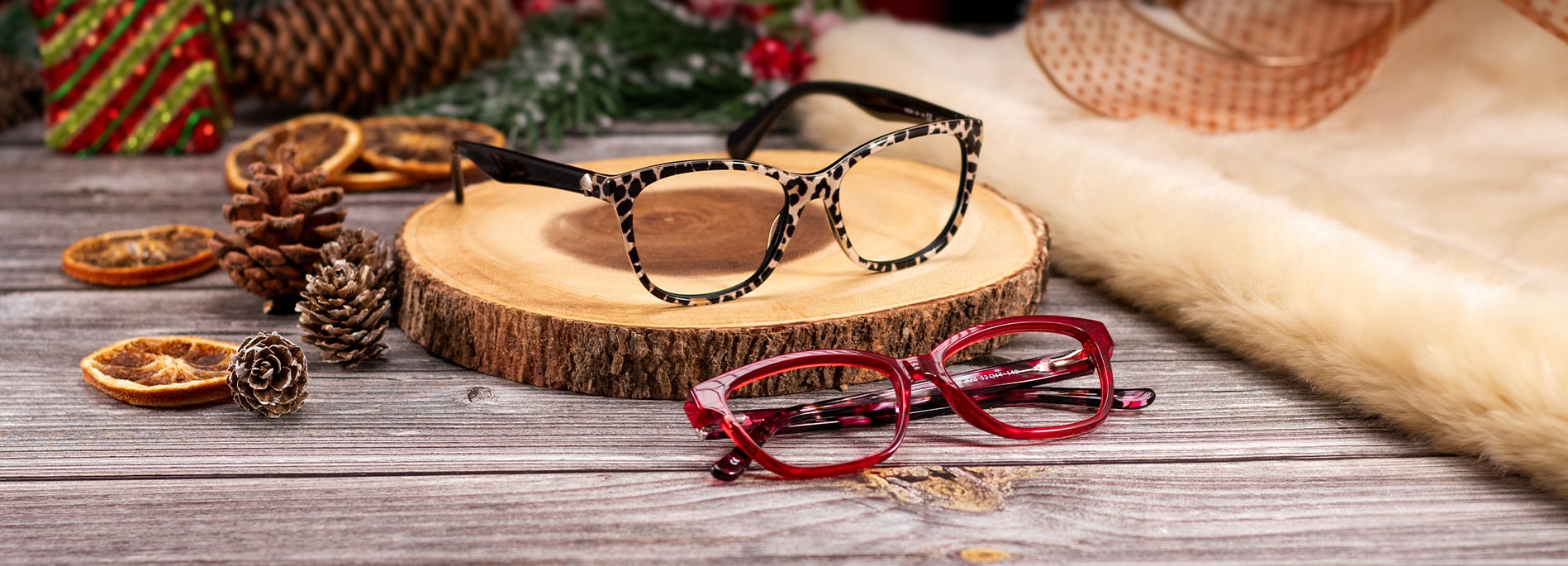 2 pairs of frames on a table surround by Christmas decorations