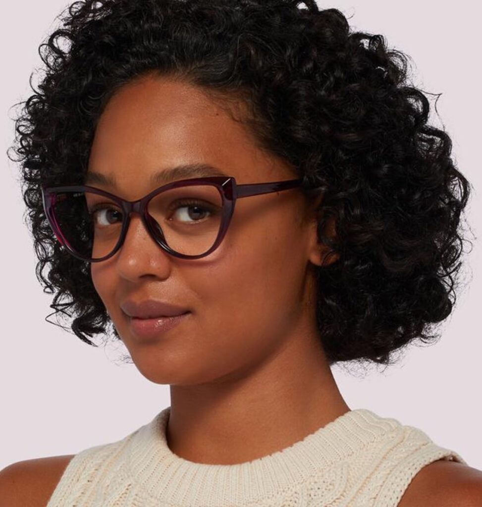 Woman with curly hair wearing purple cat-eye GD Collection frames