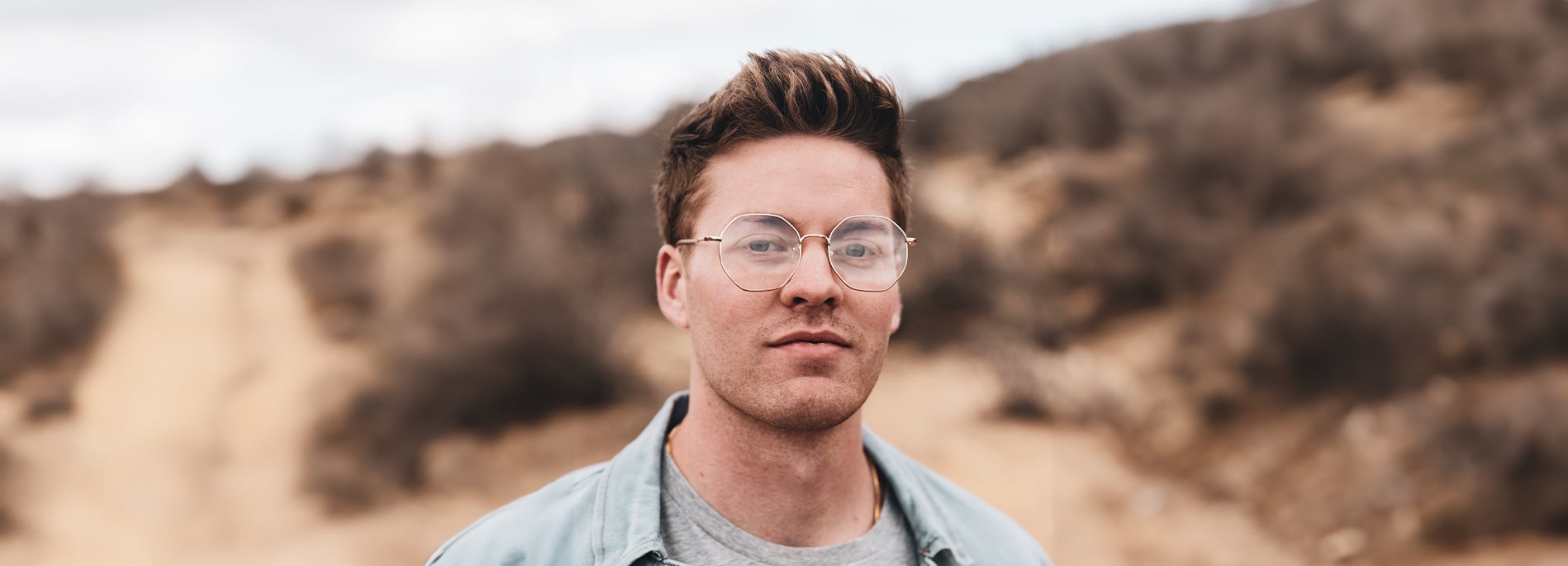 Man wearing round large metal frames outdoors