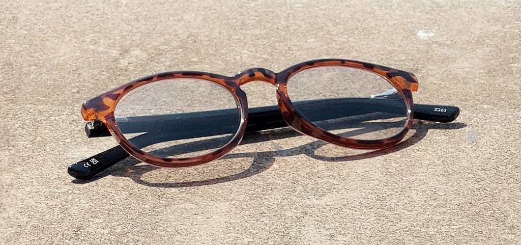 Pair of round tortoiseshell frames transitioning from clear to tinted lenses