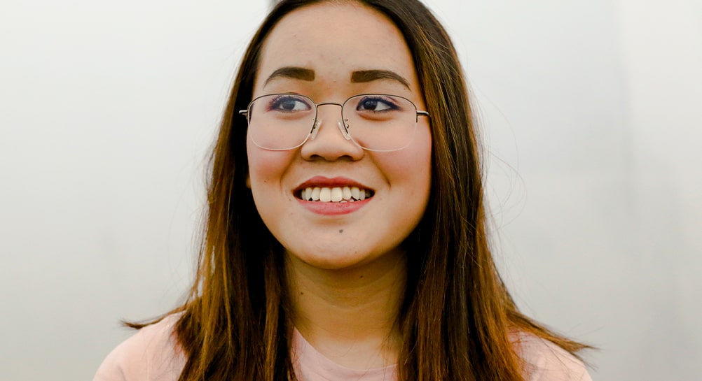Woman wearing a pair of semi-rimless metal frames smiling