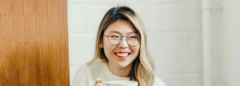 Woman wearing a pair of round metal frames smiling
