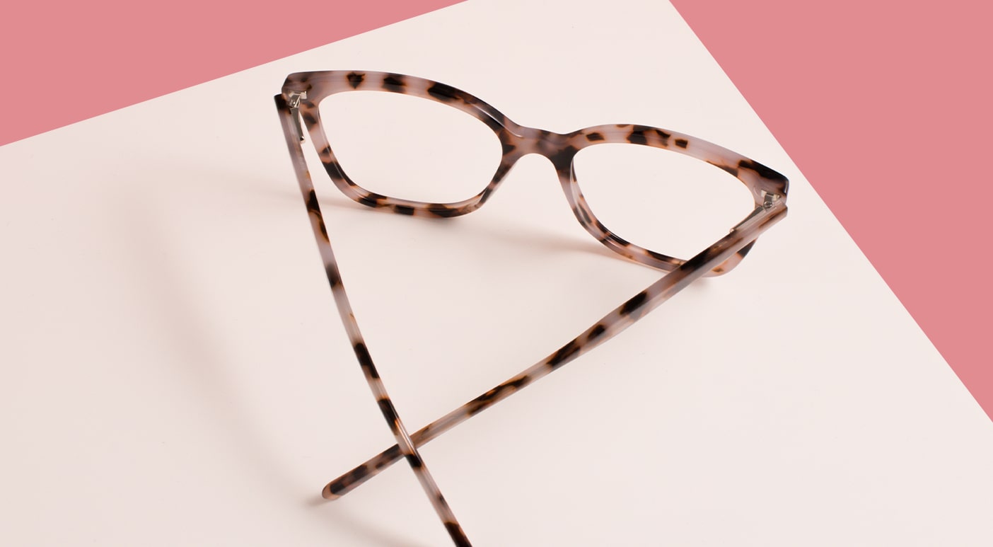 A pair of Pink Ribbon pink tortoiseshell frames with arms crossed facing away