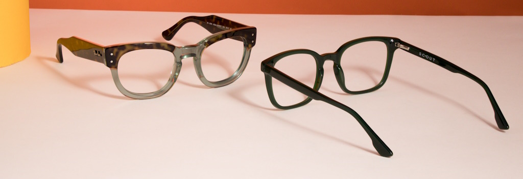 Two green frames lying on a white table facing each other