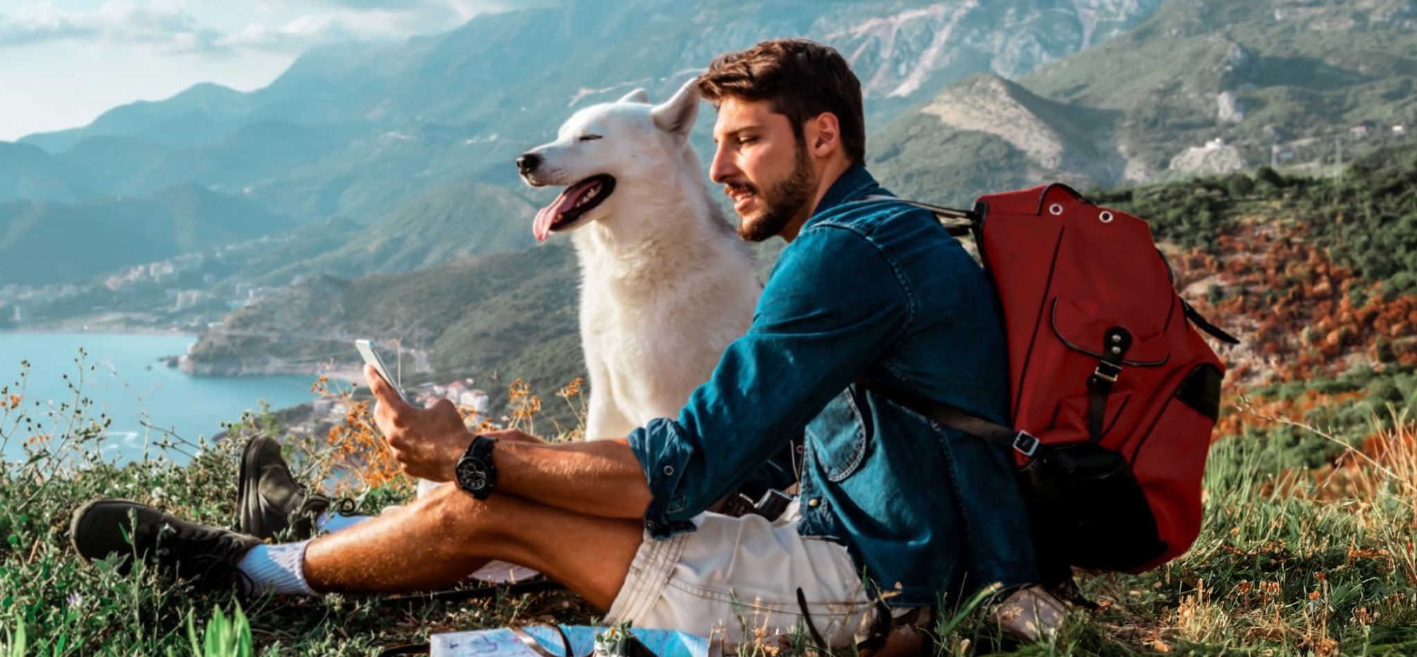 Man taking a selfie with his dog outdoors on a mountain cliff